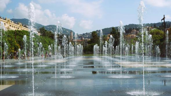 A water fountain display surrounded by greenery and historic charm captures the essence of sunny Nice, France.

