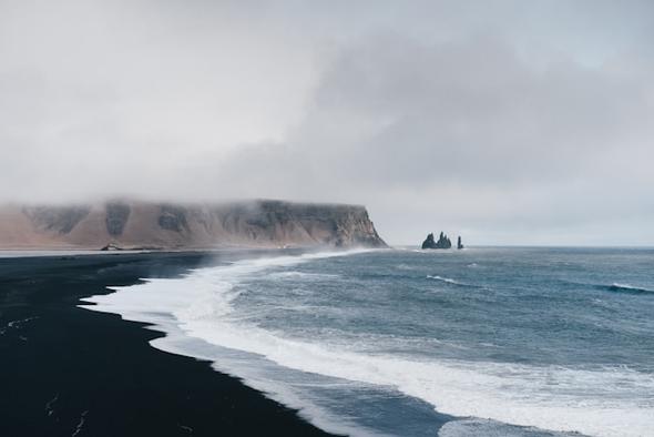 The dramatic black sands of Reynisfjara beach under a moody sky. Iceland’s unique geography attracts millions of visitors, making it essential for property owners to understand the distinction between casual home hosting and commercial accommodation licensing.