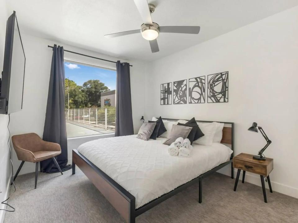 A mostly white room with grey accents and brown on some furniture.
