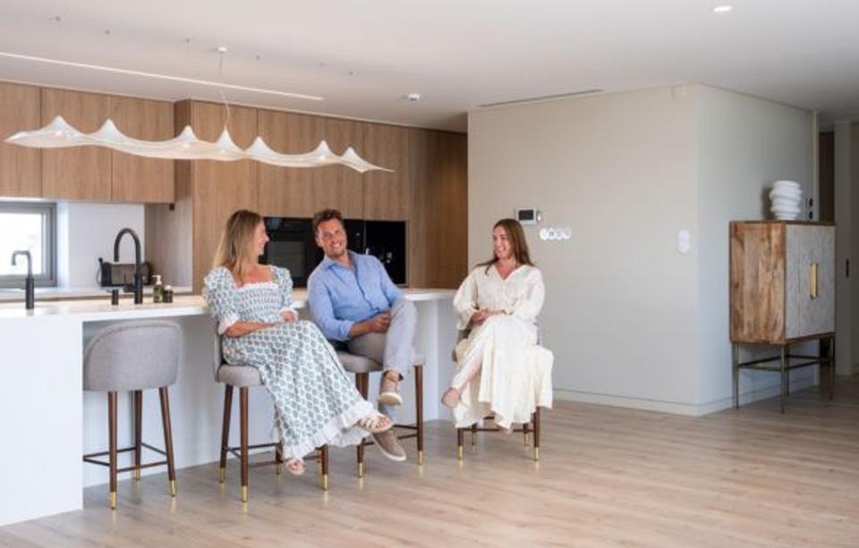 The founder and two female staff are chatting in the kitchen of one of their luxury properties. Conversations on how Hostaway helped Albany Global Property succeed. 